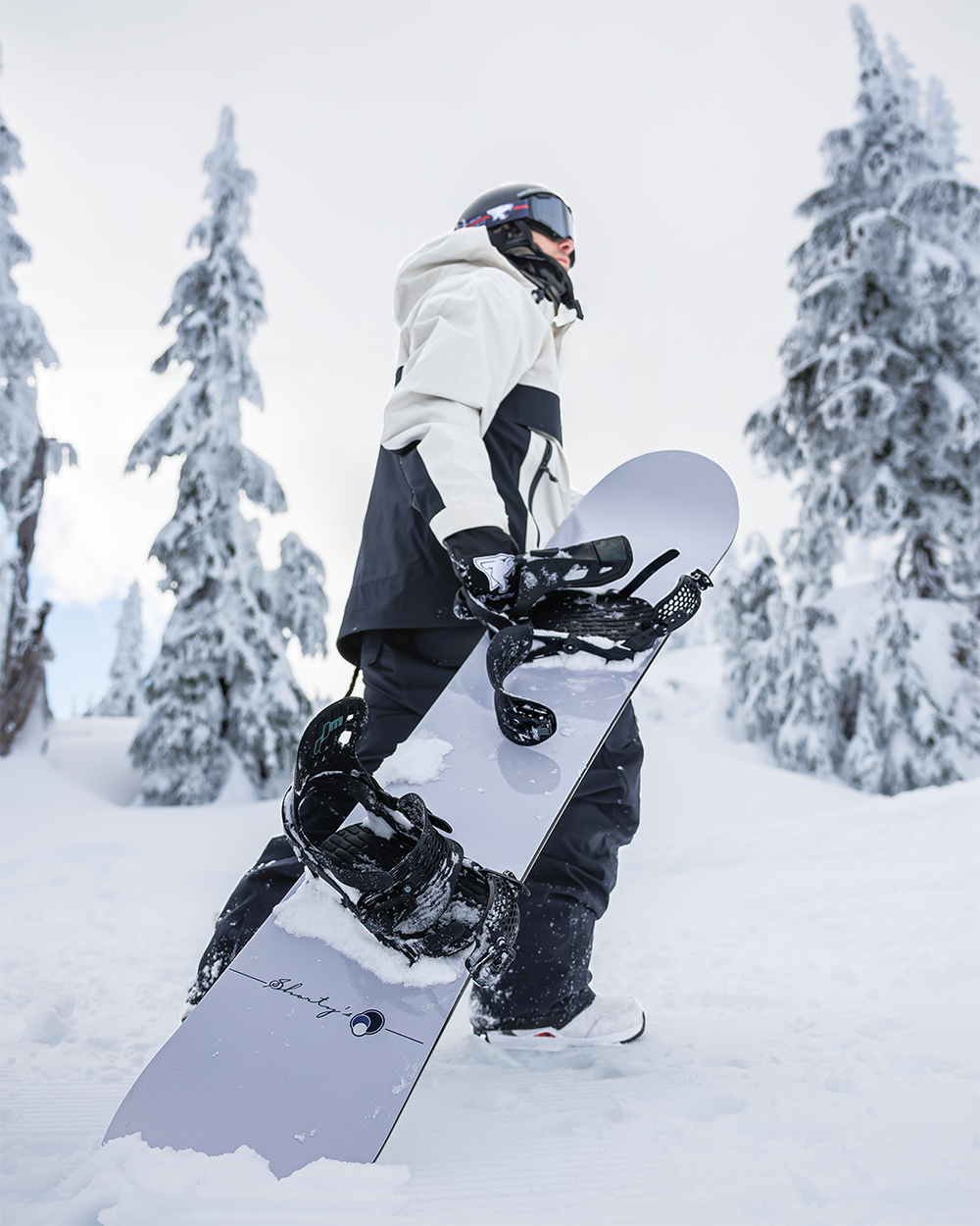 Devun Walsh holding a Shorty’s snowboard in the snow at Seymour